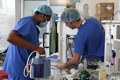 Dr. Olufolabi and Dr. Bill Nelson (former Duke Anesthesiology resident) examining an anesthetic machine before it is used