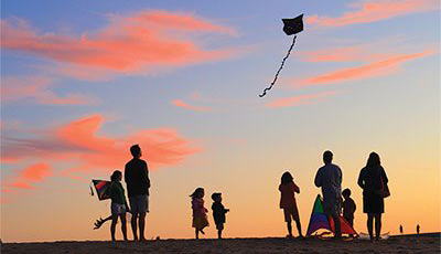 Family on vacation flying a kite