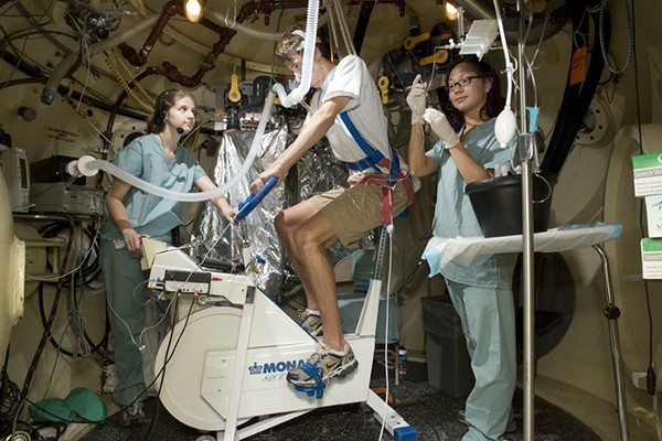 Study volunteer performing CO and exercise test at the Hyperbaric Chamber.