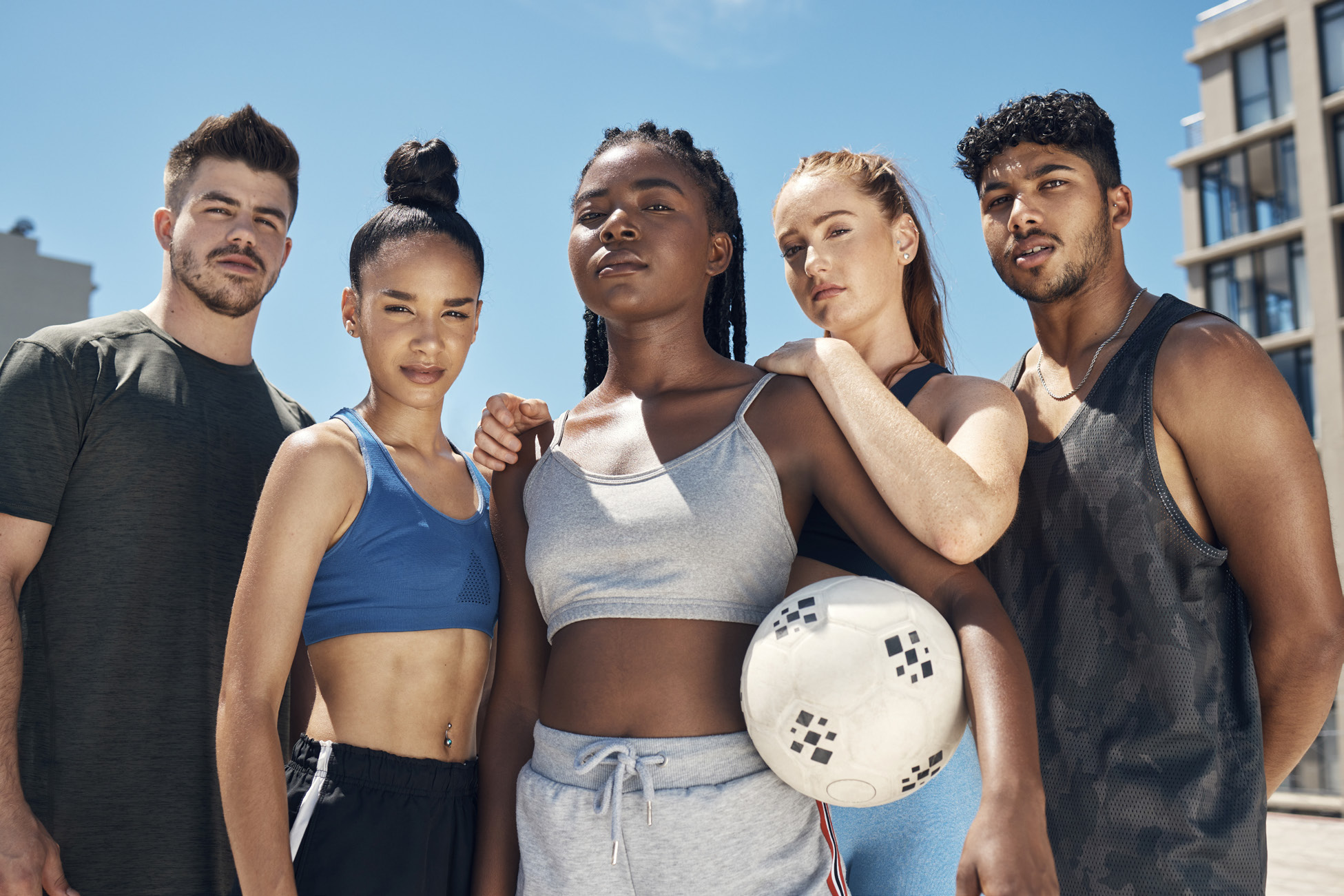 Male and female athletes posing holding a volleyball