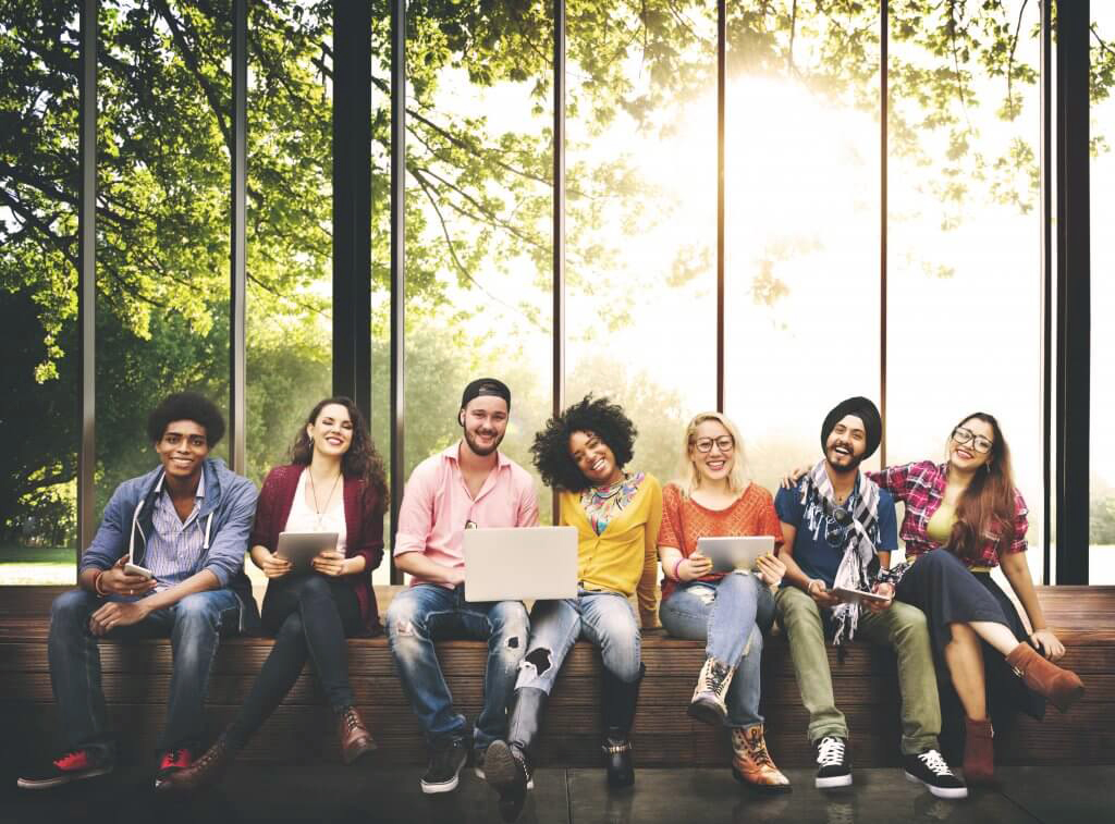 Group of young people siting on a wall.