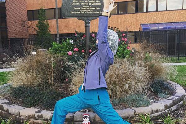 Dr. Dana Wiener is seen here doing warrior pose outside of the Durham VA Medical Center Blue Star Memorial.