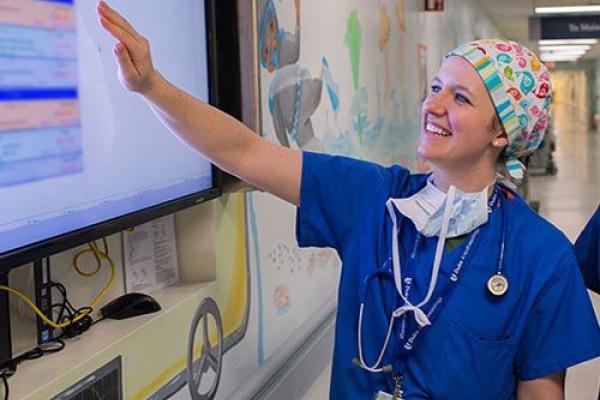 Anesthesiology Fellow looking at procedure board.