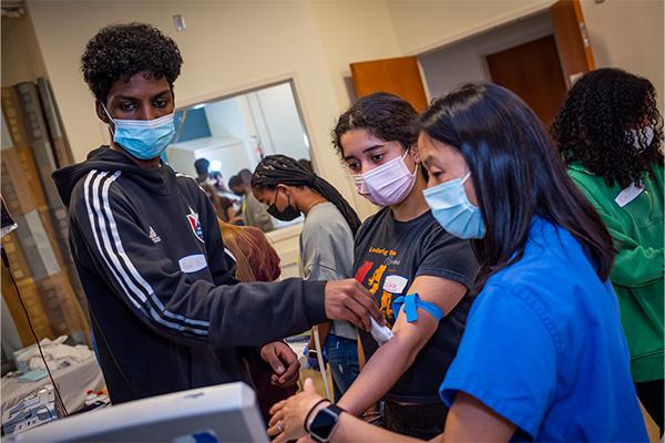 High school students performing an echo at health care event.