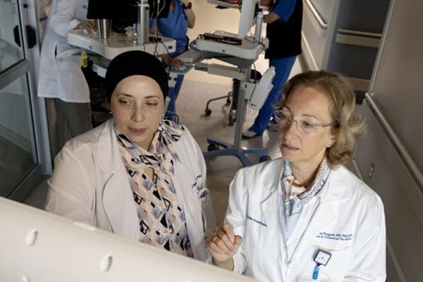 Dr. Sajdeya and Dr. Treggiari review charts in the Neuro ICU