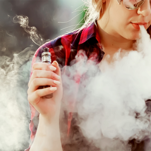 Woman vaping an e-cigarette device.
