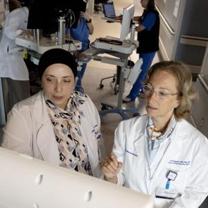 Dr. Sajdeya and Dr. Treggiari review charts in the Neuro ICU